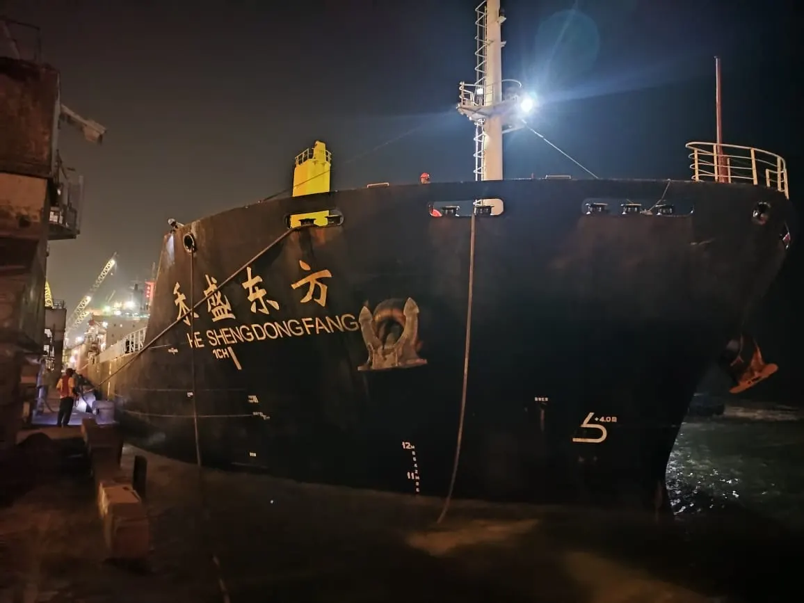 Bulk carrier alongside at night during a Cross Trade Shipping port call