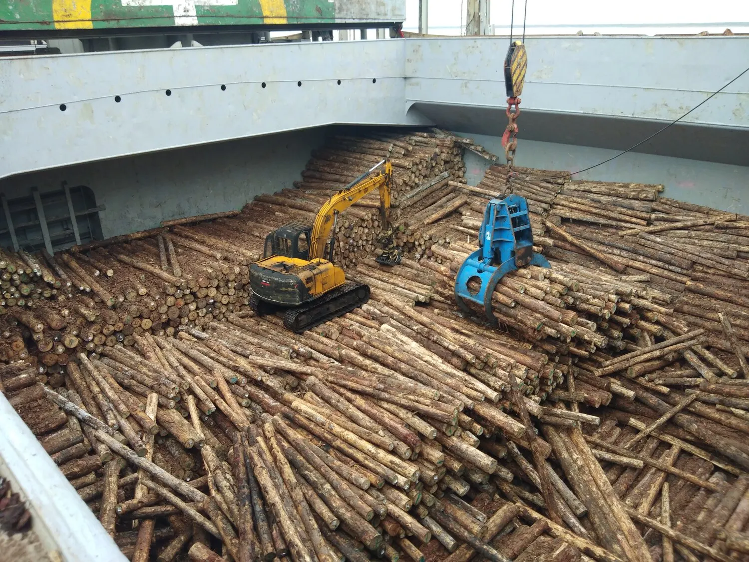 Timber logs being discharged with a log grapple