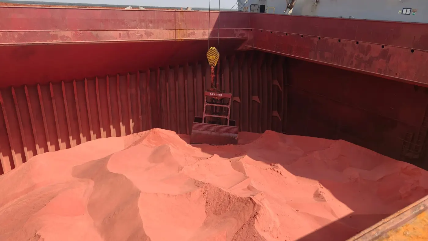 Muriate of Potash (MOP) bulk cargo in a vessel hold being discharged by grab