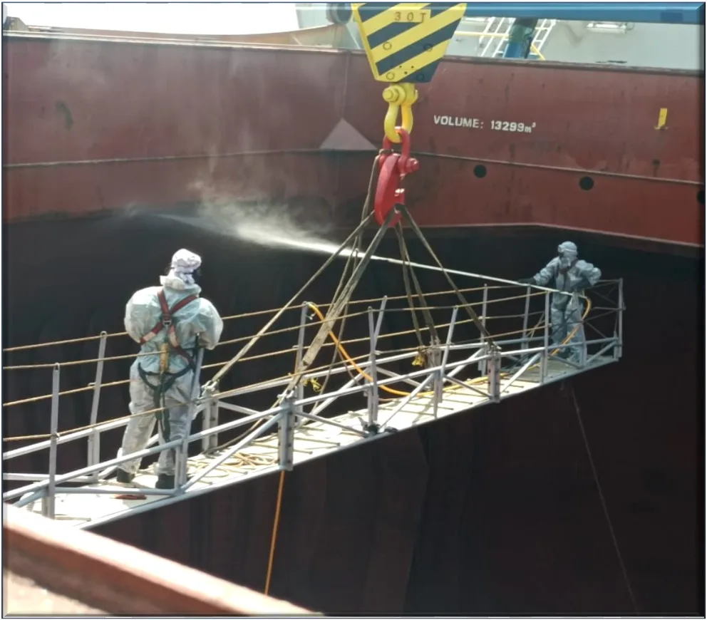 CHC team washing down a cargo hold from a suspended cradle